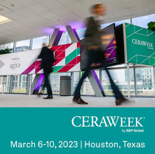 Picture shows two blurred figures walking past banners, with text that reads "CERAWeek by S&P Global, March 6-10, 2023 | Houston, Texas"