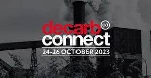 Grey scale background of heavy industry with white and red text that reads "Decarb Connect 24-26 October 2023".